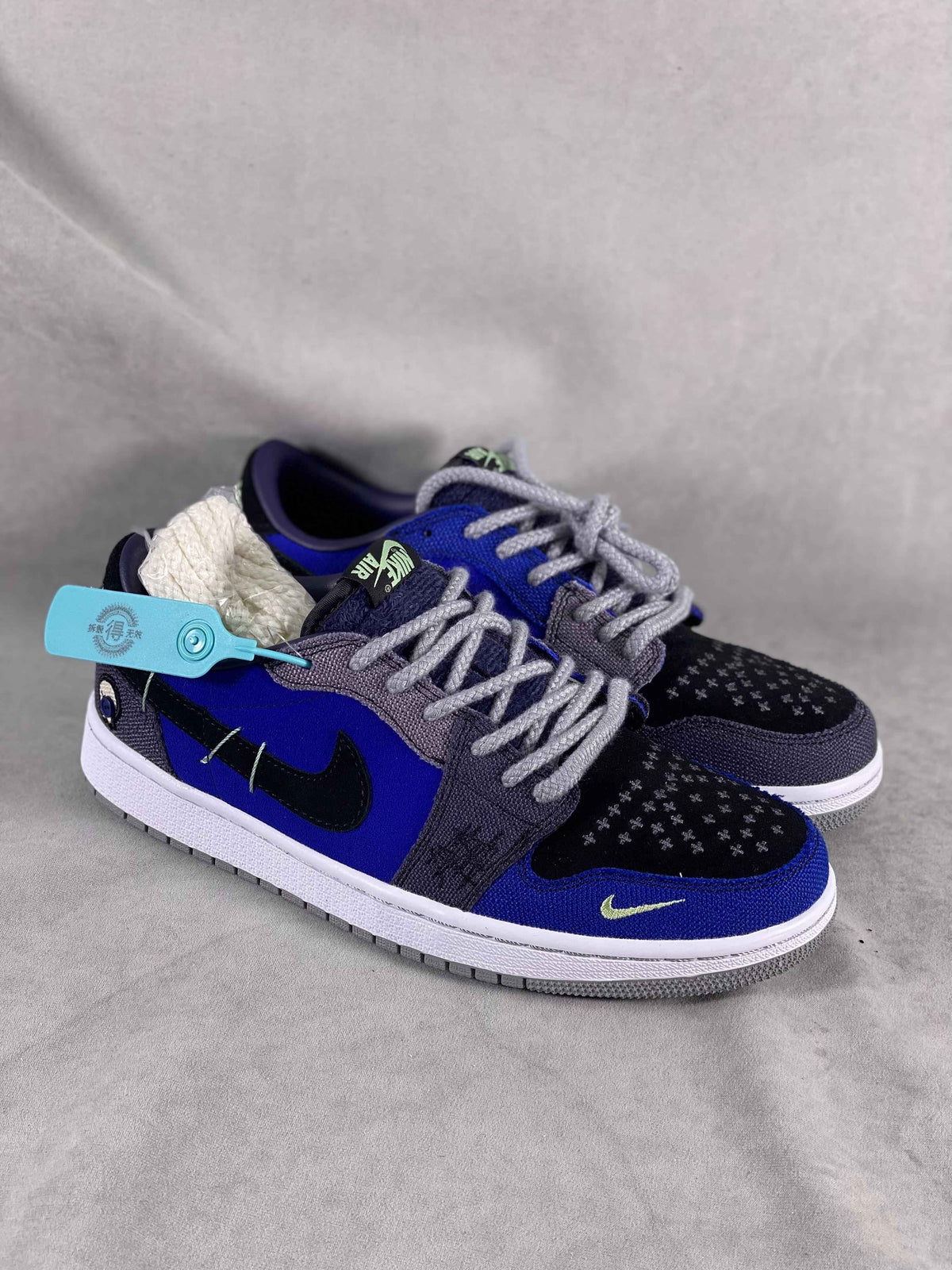 Luxury urban wear sneakers with blue, black, and grey design, displayed on a grey background.